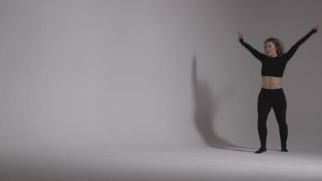Full-Length-Studio-Shot-Of-Young-Woman-Doing-Dance-Practise-Against-Grey-Background-4
