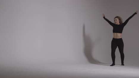 full length studio shot of young woman doing dance practise against grey background 4