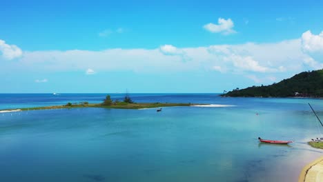 Fishing-boat-anchoring-on-shore-of-tropical-island-with-exotic-beach-washed-by-clear-water-of-turquoise-lagoon,-Thailand