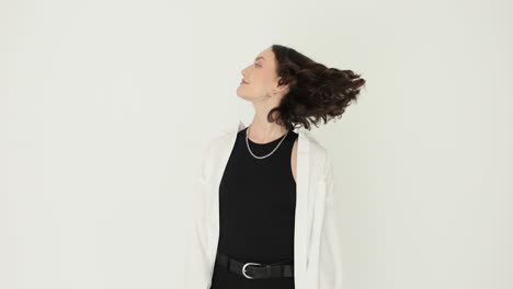 Stylish woman posing with curly hair in studio