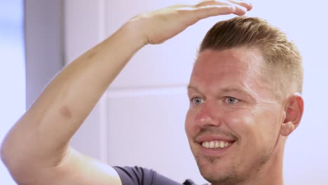 man smiling and checking hair