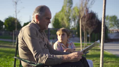 Old-man-reading-newspaper-outdoors.