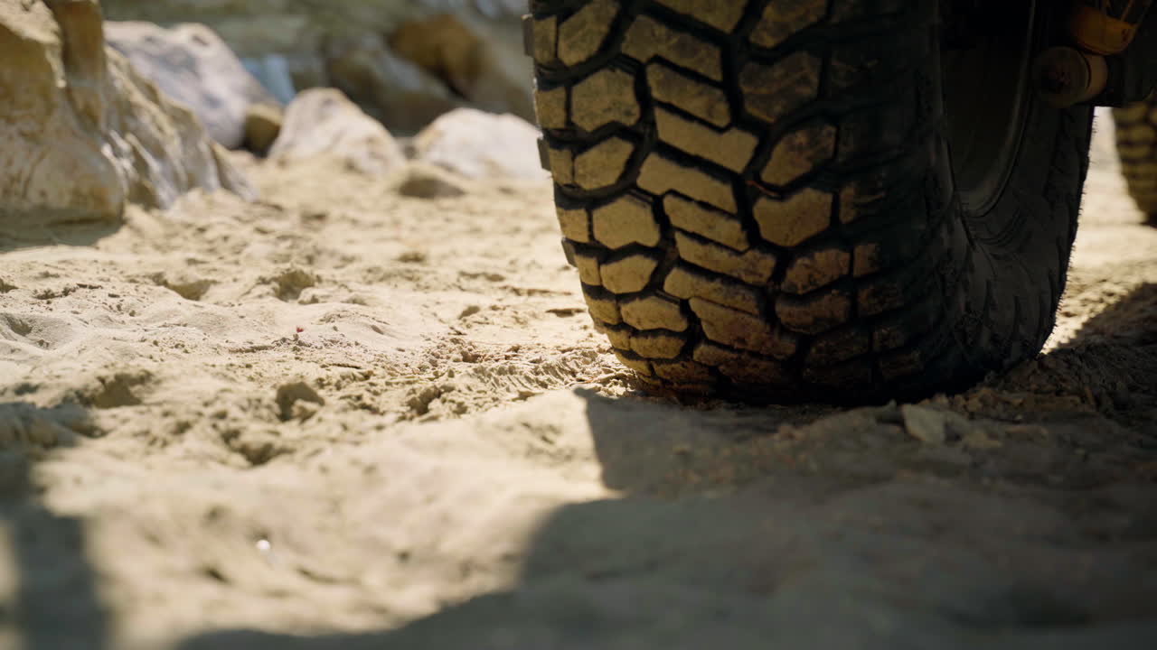 Primo piano di una gomma dell'auto parcheggiata su una spiaggia