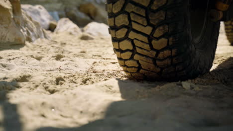 close up of a tire on the car, parked on a beach