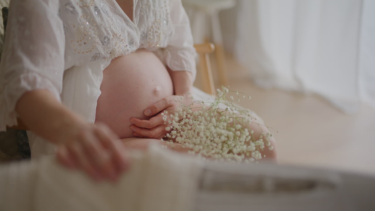 Pregnant Woman Cradles First Child in Cradle