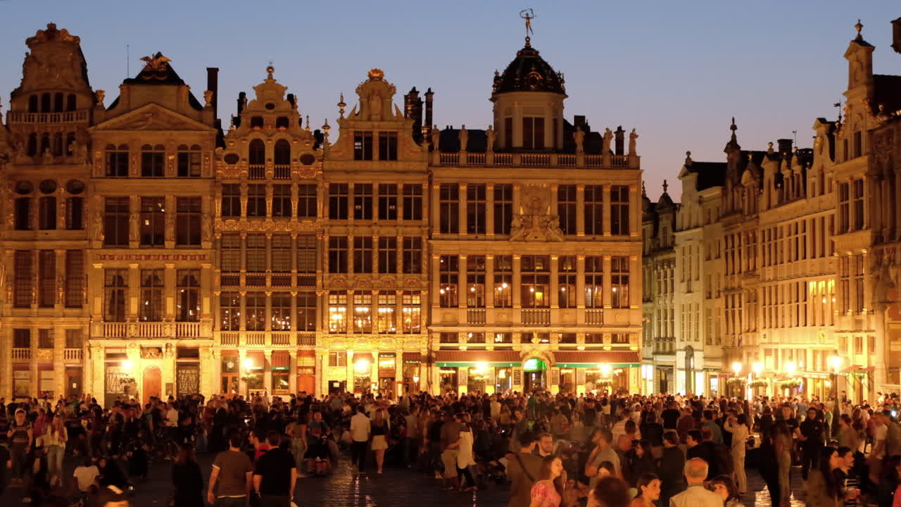 Brussels, Belgium - December 2, 2022: People moving through the Grand Place plaza central square at night