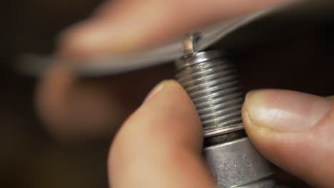 cleaning spark plug using sandpaper close up realtime