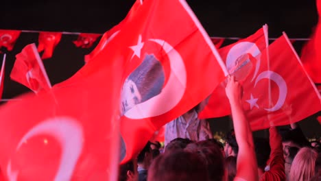 people waving turkish flags in celebration