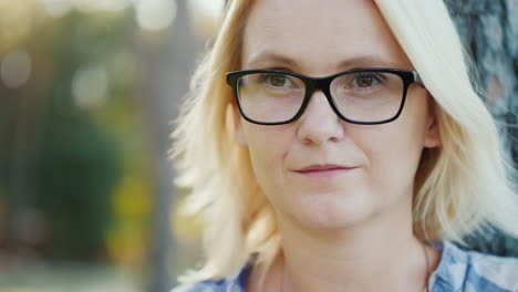 portrait of a pensive young woman in glasses he looks out into the distance the wind plays with her