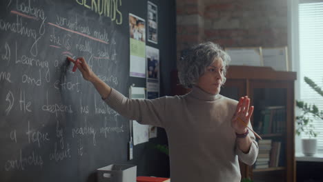 teacher pointing at blackboard and explaining english grammar lesson