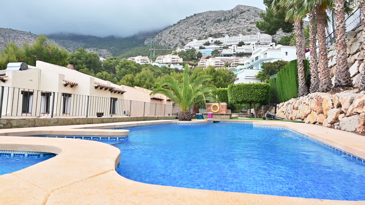 Water pool and houses with palm trees in Altea Hills Spain