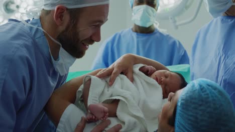 Close-up-of-Caucasian-couple-looking-at-their-newborn-baby-in-hospital