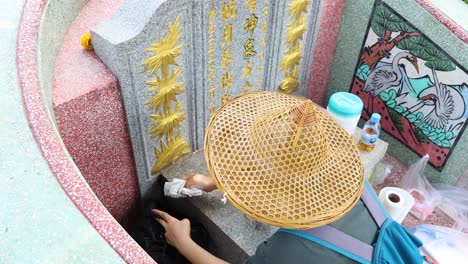 person tidying and decorating a grave site