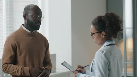 Female-Doctor-Speaking-with-Black-Patient-in-Clinic