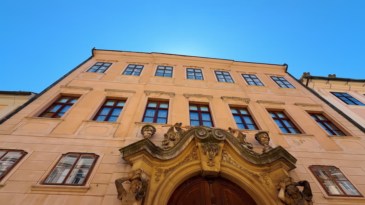 Bratislava, Slovakia, 2 June 2025: Façade of the old-fashioned four-storied buildings with stunning molding above the entrance. Architecture of Bratislava, Slovakia. Low angle view
