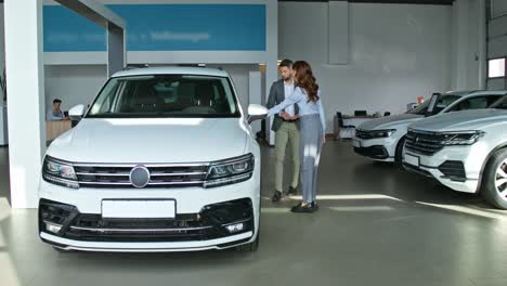 car salesperson showing off a new suv