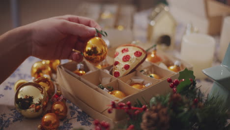 man removing bauble from box at table