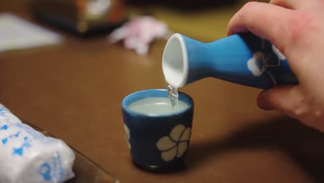 bottle of hot sake pouring in slow motion