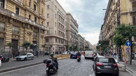 street view of car traffic on a busy city street at naples in italy during rush hour.