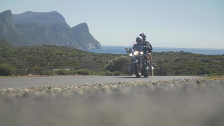 Moto che passa al rallentatore in mezzo a un paesaggio stradale sudafricano.