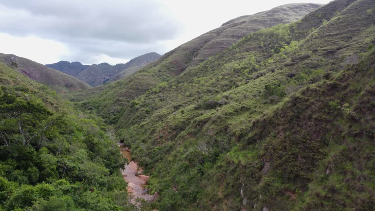las empinadas laderas boscosas de las montañas descienden hasta el remoto valle estrecho del río