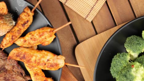 disparo superior de la mesa con filete, pinchos de pollo, salmón y verduras