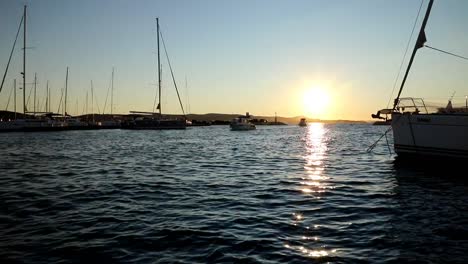 boats and yachts enter and exit marina at sunset in biograd in croatia