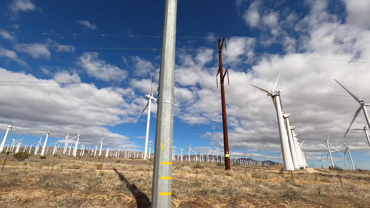 conduciendo a través del desierto en california por los hermosos molinos de viento - ondulado amplio