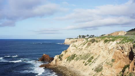 Aerial-Shot-flying-along-cliffs-of-Palos-Verdes-Coastline-towards-Point-Vicente-Lighthouse-with-waves-crashing-below