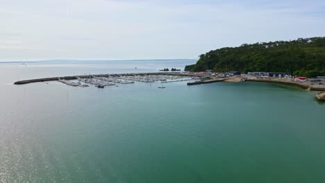 Approaching drone movement to the breakwater and Morgat marina entrance leading to open sea at Crozon peninsula, Brittany, France