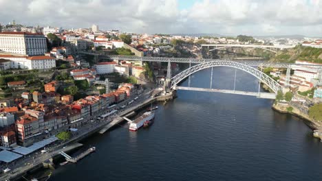 drone shot flying backwards with bridge in view in porto portugal at sunset