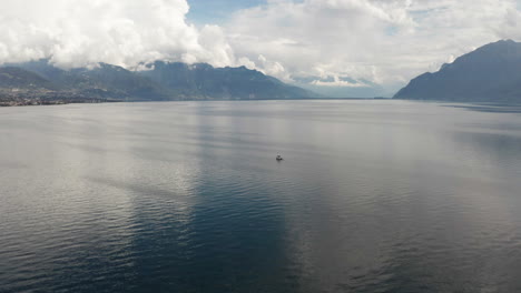 Flying-up-to-boat-lying-anchored-on-beautiful-lake-with-mountains-in-the-distance