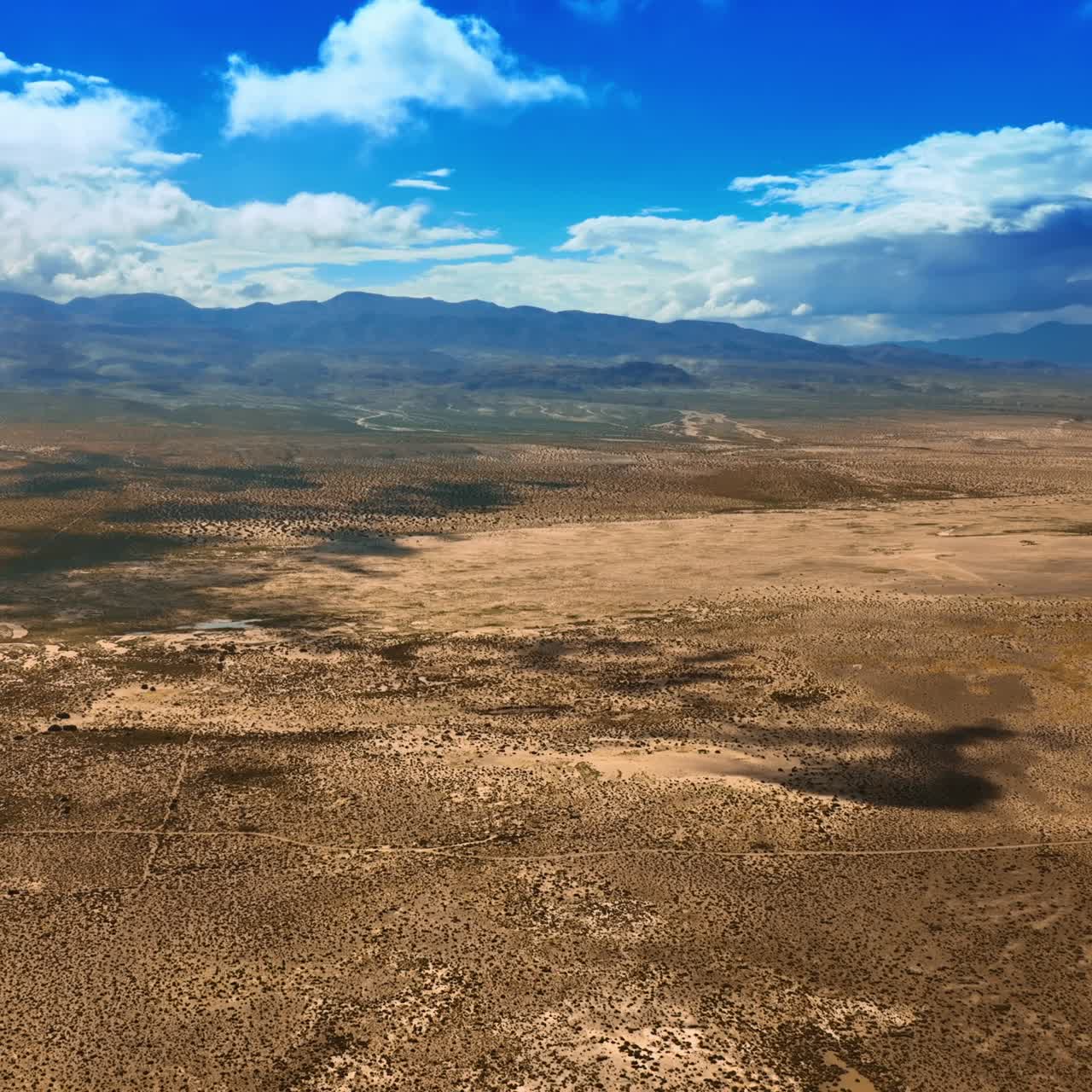 Amazing scenery of a desert in California. Dry lifeless landscape of Death Valley under the azure sky with white clouds. Top view