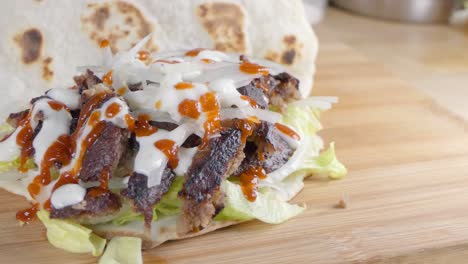 zeitlupen-slider-aufnahme vom falten eines naan-brots über einem döner-kebab zu hause in der küche