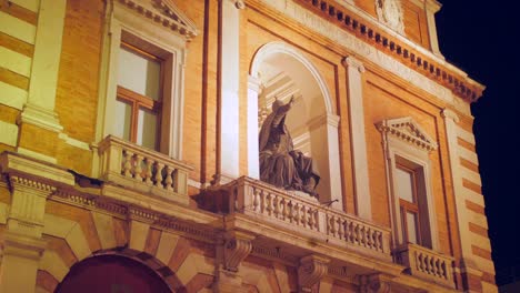 Hermosa-Toma-Inclinada-Del-Famoso-E-Histórico-Palazzo-Del-Ridotto-Por-La-Noche-Con-La-Estatua-Del-Papa-En-Cesena,-Italia