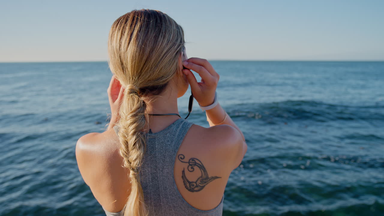 Mulher corredora relaxando na praia com música