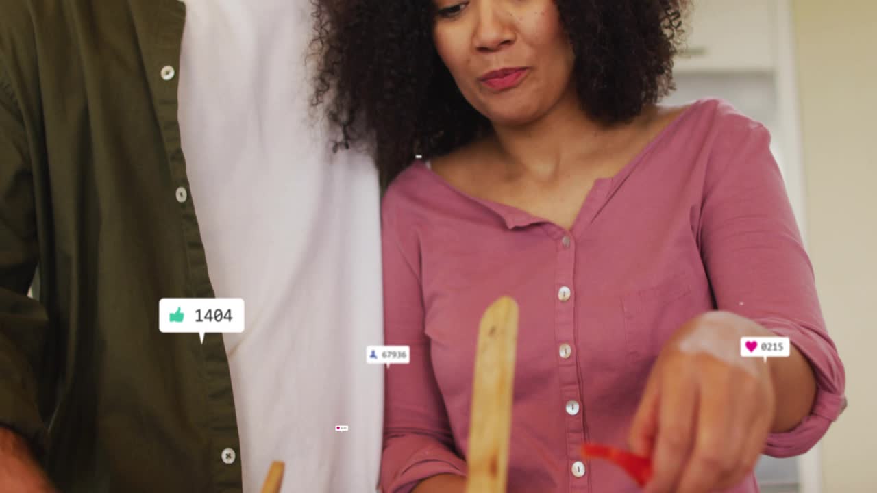Couple slicing cucumber chopping pepper on board, popping icons showing social media engagement