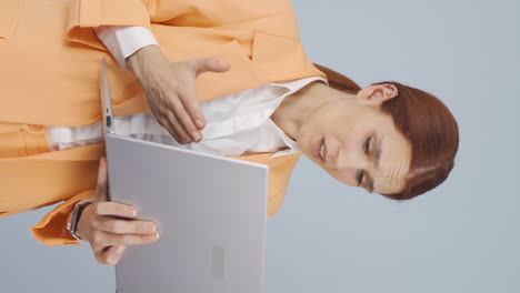 vídeo vertical de una mujer de negocios enojada cierra enojadamente su portátil.