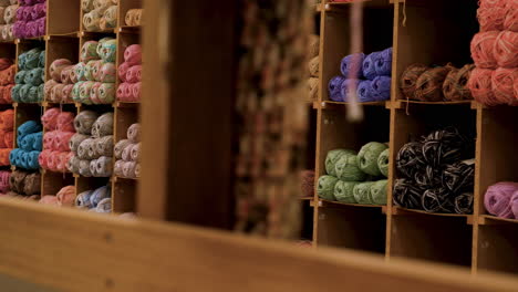 colorful balls of yarn displayed on shelves in knitting store