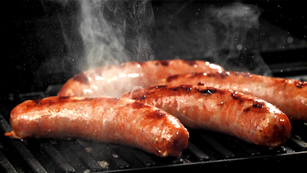 Deliziose salsicce che cuociono su un barbecue