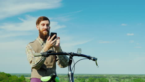 a young man uses a smartphone travels by bicycle 2