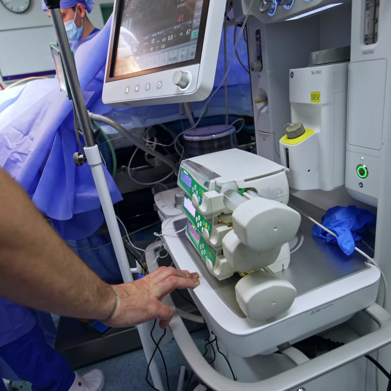 Modern advanced innovative equipment in surgery room. Anesthesiologist monitoring the patient's condition looking at screen of lung ventilator