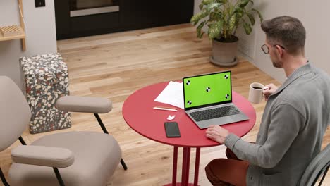 man with green-screened portable computer