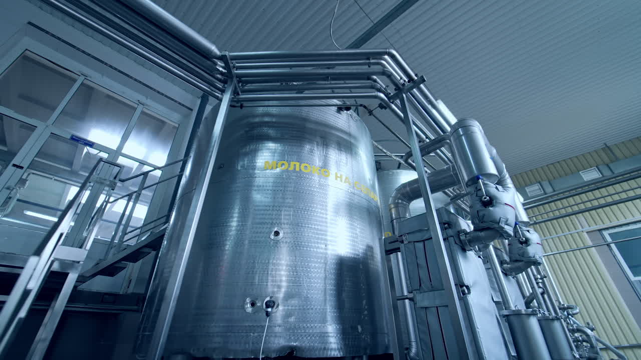 Large steel cistern for milk. Modern equipment inside the factory for production of dairy products. Close up with gradual distancing.