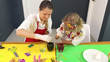 madre e hija pintando huevos de pascua