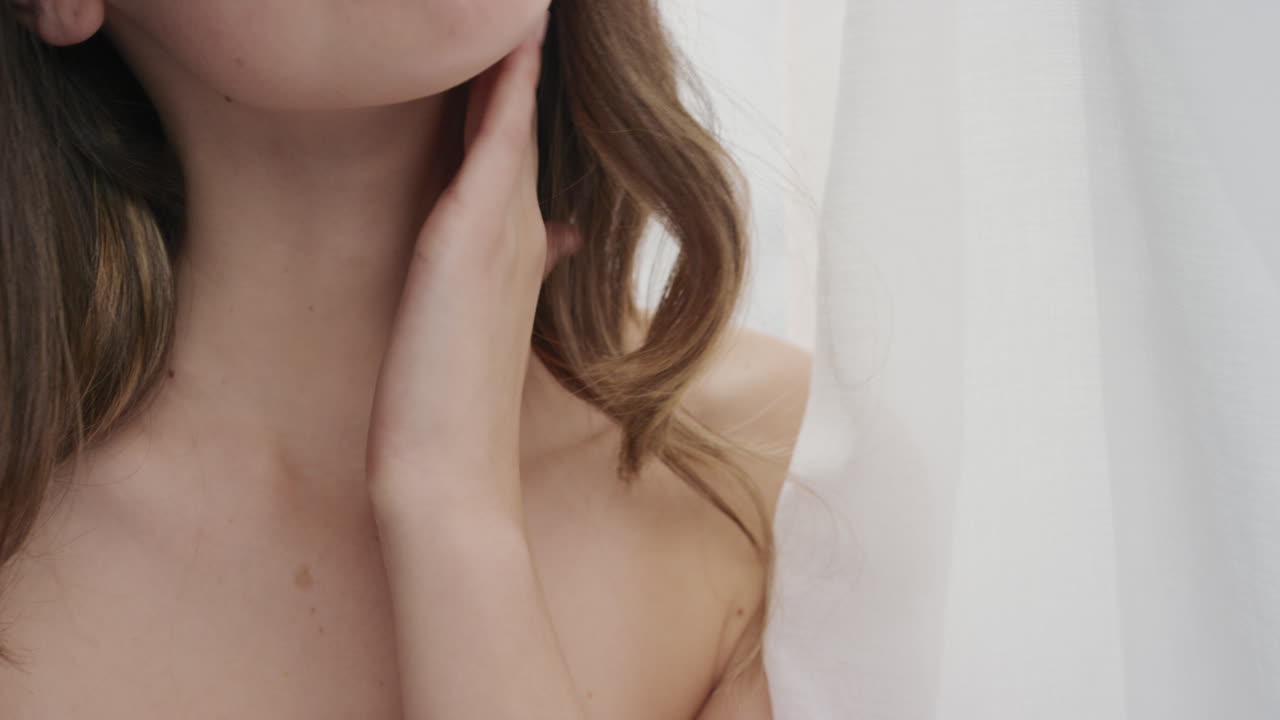 retrato de cerca de una mujer joven hermosa tocando una piel suave y saludable acariciando el cuerpo con las manos disfrutando de un cuidado de la piel de lujo belleza femenina en fondo blanco entre las sábanas