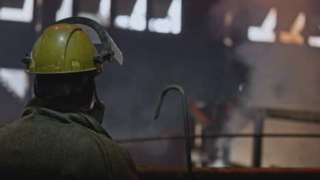 industrial worker observing hot metal process