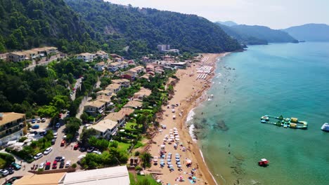 Aerial view of lush coast, beach, and ocean under blue sky