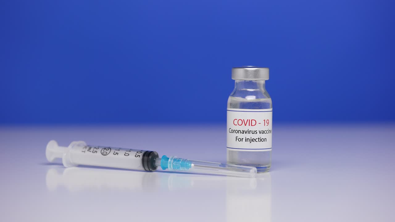 covid-19, vacunas contra el coronavirus, viales de medicamentos, frascos de medicamentos, inyección con jeringa. vacunación, inmunización, tratamiento para curar la infección por covid-19. pantalla azul, llave de croma. acercamiento. movimiento lento