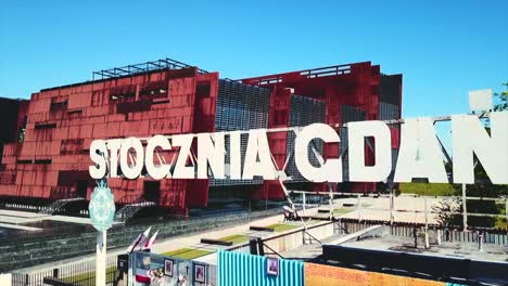 drone flying from the stocznia gdanska sign to the shipyard panorama